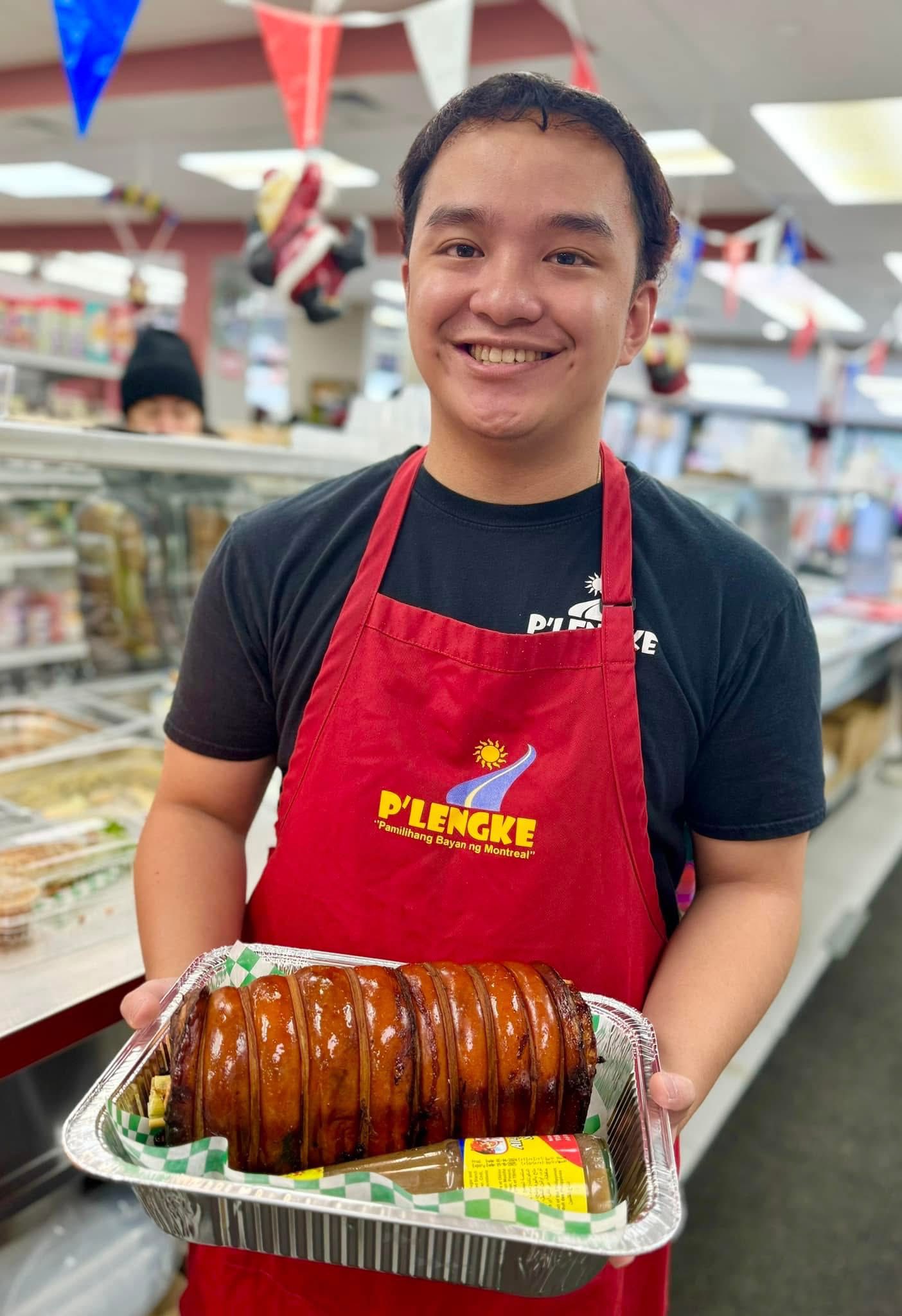 Team member holding lechon roll with warm smile