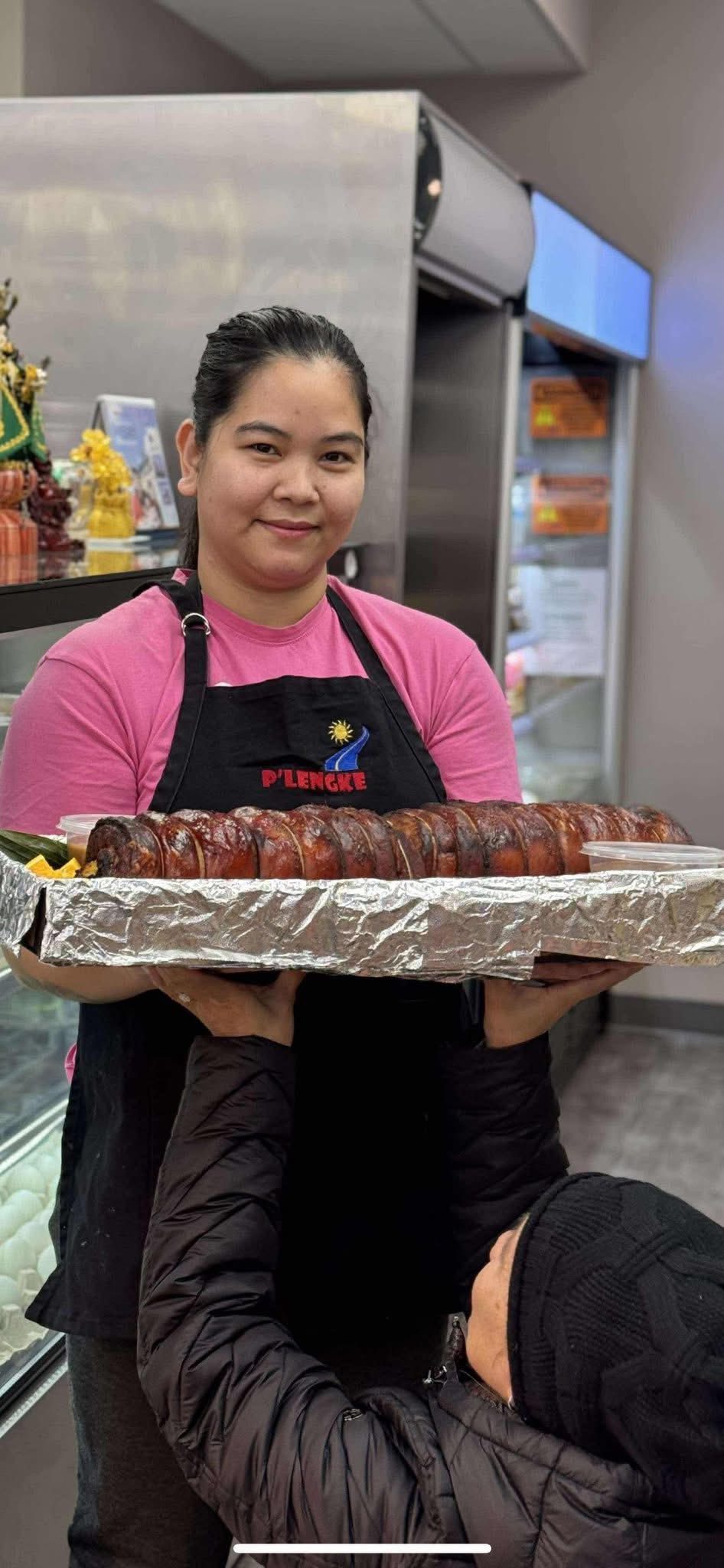 Staff member displaying tray of lechon slices